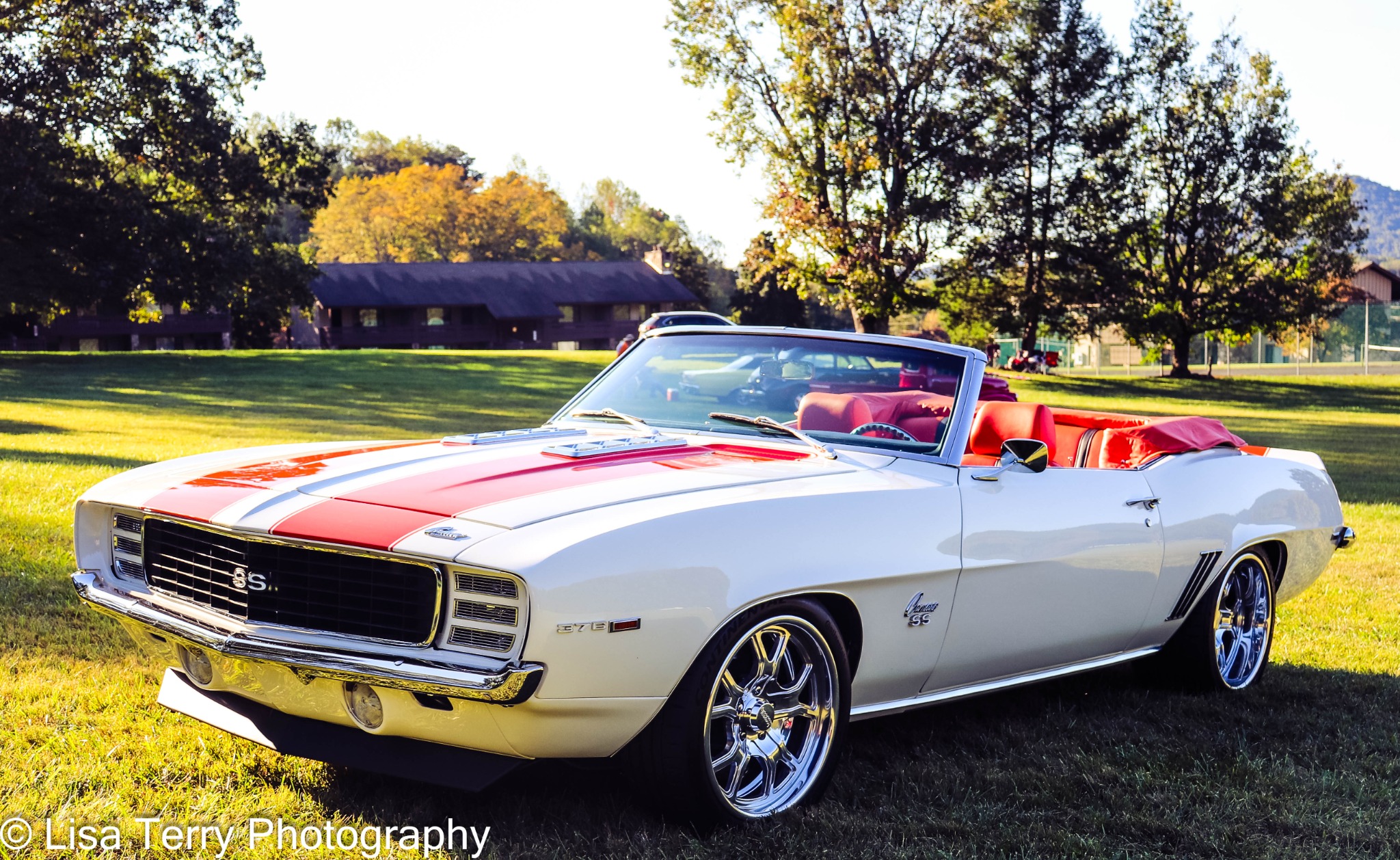 White and red classic Camaro SS convertible on grass