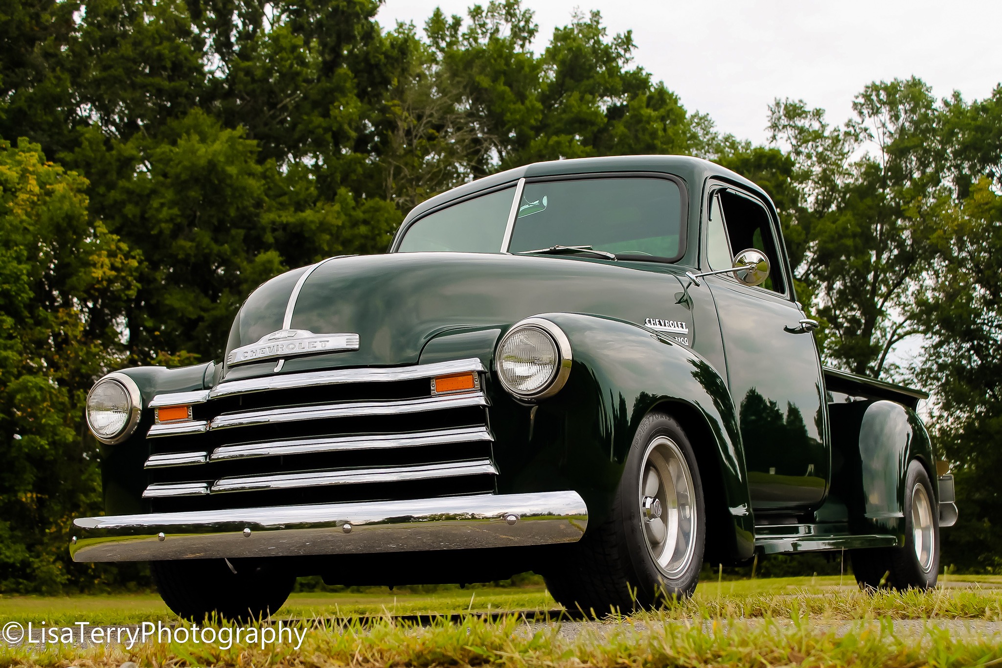 Dark green vintage Chevrolet pickup photographed from a low angle