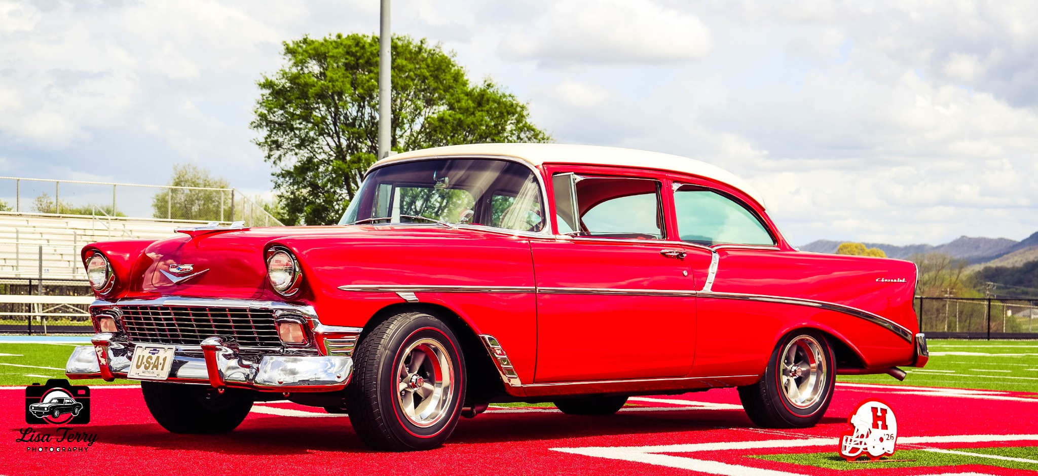 Red and white 1956 Chevrolet photographed on a football field